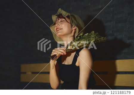 サウナでヴィヒタを使う女性　撮影協力・白玉の湯 泉慶 121188179