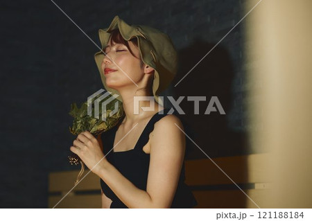 サウナでヴィヒタを使う女性　撮影協力・白玉の湯 泉慶 121188184