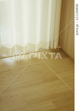 A minimalist interior in wood tones with warm sunlight streaming in. 121188606