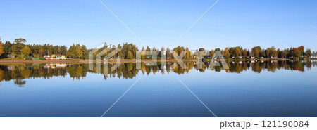 Calm autumn day, colorful trees reflecting in Lake Vanern, Sweden. 121190084
