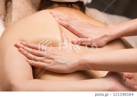 若いアジア人女性は背中のオイルマッサージを受けています. 若いアジア人女性は背中のオイルマッサージを受けています. 121190164