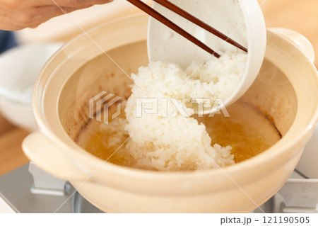 鶏鍋の残り汁でおじや(雑炊)を作る男性の手元 鶏鍋の残り汁でおじや(雑炊)を作る男性の手元 121190505