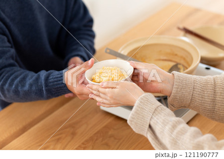 鶏の水炊き鍋のスープで雑炊（おじや）を楽しむミドル夫婦 121190777