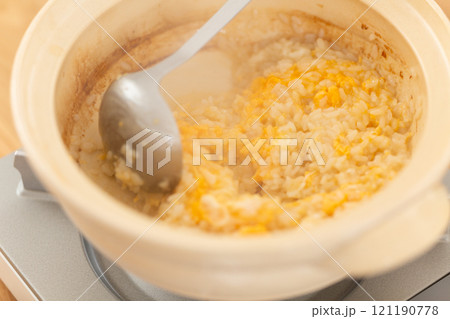 鶏鍋の残り汁でおじや（雑炊）を作る男性の手元 121190778