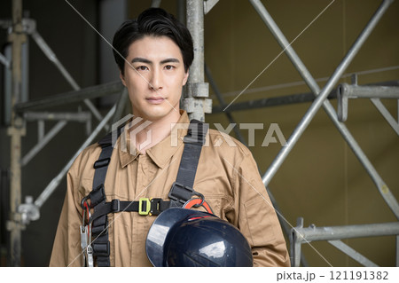現場で安全ベルトをした真剣な表情のカメラ目線 ガテン系の転職や求人の腕を組む イメージに	 121191382