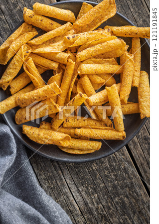 Rolled nachos tortilla chips on plate on wooden table. Top view. 121191845