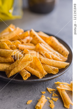 Rolled nachos tortilla chips on plate on kitchen table. Rolled nachos tortilla chips on plate on kitchen table. 121191849