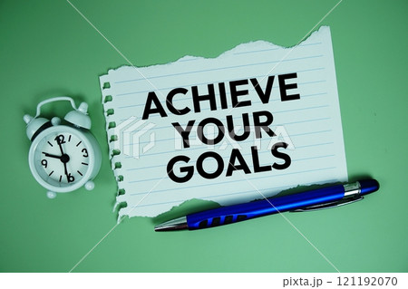Achieve Your Goals text motivational and inspiration quote with alarm clock on green background 121192070