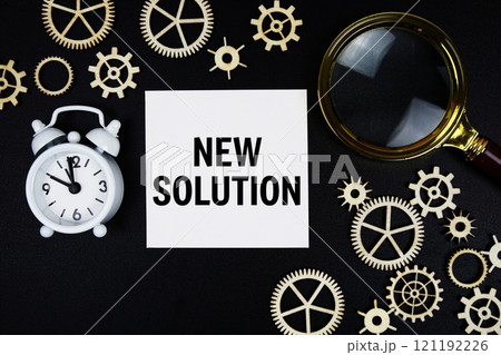 New Solution text message on sticky note with magnifying glass and alarm clock on black background 121192226