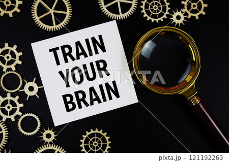 Train Your Brain text with magnifying glass on black background Train Your Brain text with magnifying glass on black background 121192263