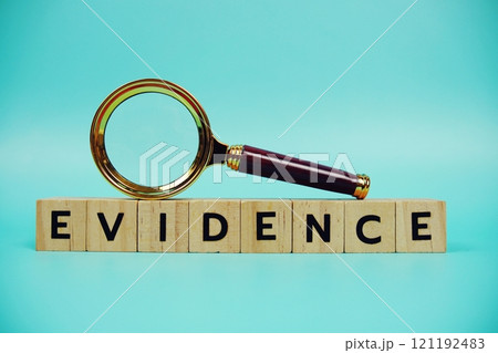 Evidence with wooden blocks alphabet letters and Magnifying glass on blue background 121192483