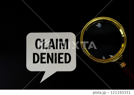 Claim Denied text on speech bubble with magnifying glass top view on black background Claim Denied text on speech bubble with magnifying glass top view on black background 121193331