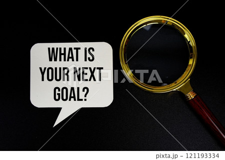 What is your next goal? text on speech bubble with magnifying glass top view on black background 121193334