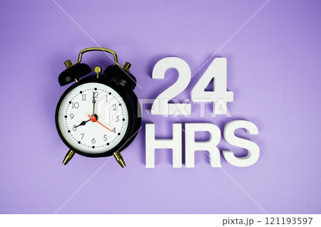 24 Hrs alphabet letters and alarm clock top view on purple background 121193597