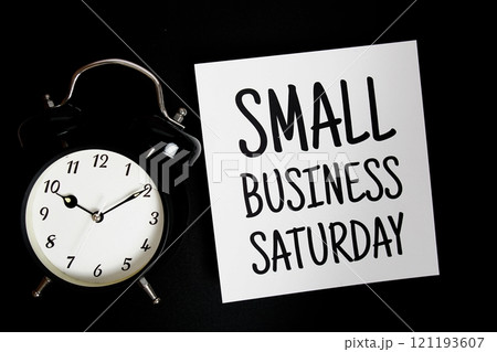 Small Buniness Saturday text with alarm clock on black background Small Buniness Saturday text with alarm clock on black background 121193607