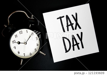 Tax Day Word alphabet letter And Alarm Clock top view on black background Tax Day Word alphabet letter And Alarm Clock top view on black background 121193609