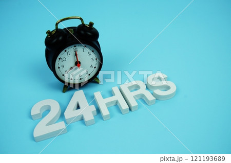 24 Hrs alphabet letters and alarm clock top view on blue background 24 Hrs alphabet letters and alarm clock top view on blue background 121193689