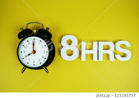 8 Hrs alphabet letters and alarm clock top view on yellow background 121193757