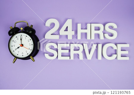 24 Hrs Service alphabet letters with alarm clock top view on purple background 24 Hrs Service alphabet letters with alarm clock top view on purple background 121193765