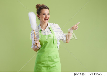 smiling woman in green apron and rubber gloves on green 121195220