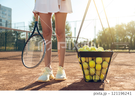 Close up of a basket with yellow tennis balls on the tennis courts Close up of a basket with yellow tennis balls on the tennis courts 121196241