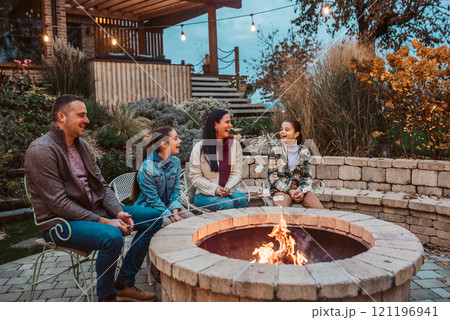 Family roasting marshmallows over open flame, campfire on backyard. Family roasting marshmallows over open flame, campfire on backyard. 121196941