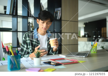 Designer holding smartphone working on new mobile application interface design at desk Designer holding smartphone working on new mobile application interface design at desk 121197035