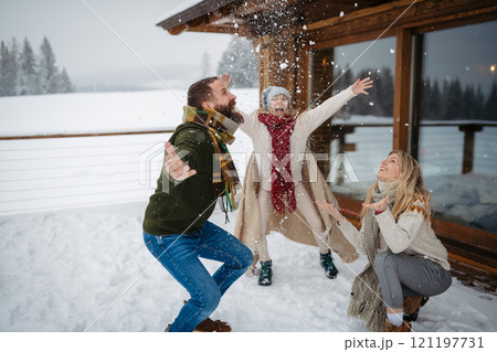 Family having fun during snowfall, throwing snow in the air. Family having fun during snowfall, throwing snow in the air. 121197731