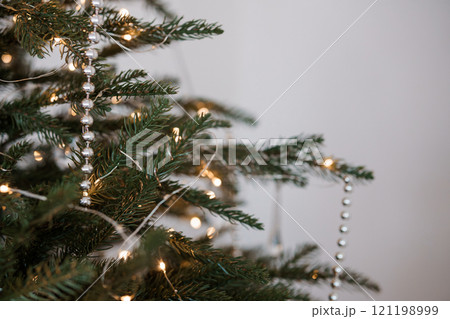 Elegant Christmas Tree Decorated with Silver Beads and Warm Lights Elegant Christmas Tree Decorated with Silver Beads and Warm Lights 121198999