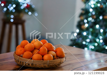 Vibrant Basket of Oranges Surrounded by Holiday Decor Vibrant Basket of Oranges Surrounded by Holiday Decor 121199028