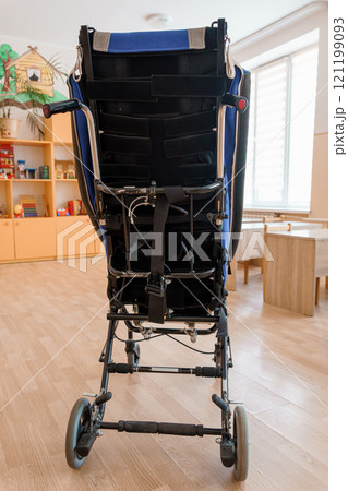 A Sturdy Blue Baby Stroller from the Rear View in a Bright Room 121199093