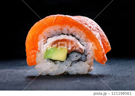 Salmon sushi with avocado and cream cheese, uramaki roll on a black background 121199561