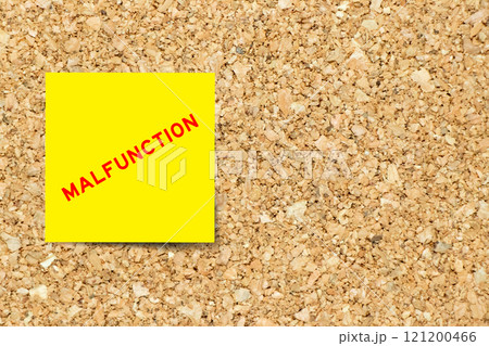 Yellow note paper with word malfunction on cork board background with copy space 121200466