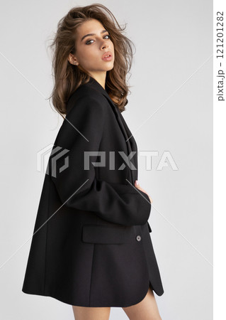 Beautiful young woman with brown hair In Black Blazer looks camera isolated on white background. Portrait Fashion model posing in studio, beauty, elegance and modern style Beautiful young woman with brown hair In Black Blazer looks camera isolated on white background. Portrait Fashion model posing in studio, beauty, elegance and modern style 121201282