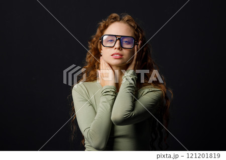 Young red haired woman wearing glasses looking at camera with joyful smile 121201819