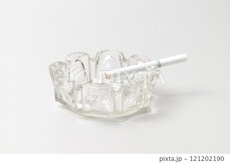 ガラスの灰皿に置かれた未使用の煙草 121202190