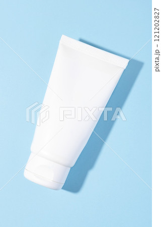 A white cosmetic tube on a pastel blue background A white cosmetic tube on a pastel blue background 121202827