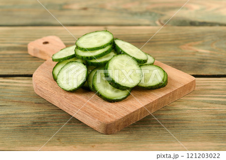 Close-up of fresh cucumber sliced into rings on a cutting board. 121203022