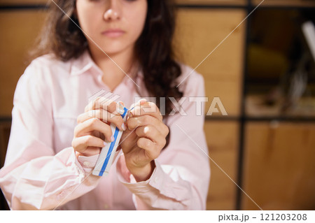 Woman dressed office attire, unpack medical preparation in sachet prescribed for treatment. Doctor's appointments and treatment. 121203208
