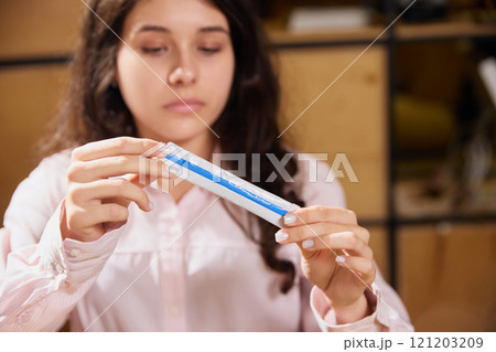 Woman dressed office attire, holds medical preparation in sachet prescribed for treatment. Doctor's appointments and treatment. Woman dressed office attire, holds medical preparation in sachet prescribed for treatment. Doctor's appointments and treatment. 121203209