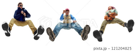 Fashionable young people wearing bold, streetwear-inspired outfits, dynamically posing against white background. Bottom view Fashionable young people wearing bold, streetwear-inspired outfits, dynamically posing against white background. Bottom view 121204825
