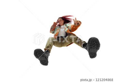 Confident young woman with vibrant red hair in a playful and dynamic pose wears colorful oversized jacket, beige corduroy pants, and black boots Confident young woman with vibrant red hair in a playful and dynamic pose wears colorful oversized jacket, beige corduroy pants, and black boots 121204868