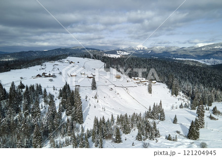 Winter landscape with small village houses between snow covered forest in cold mountains 121204945