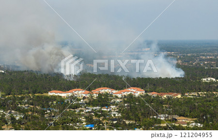 Wildfire burning severely during dry winter season in North Port city, Florida. Thick smoke rising up over suburb homes Wildfire burning severely during dry winter season in North Port city, Florida. Thick smoke rising up over suburb homes 121204955