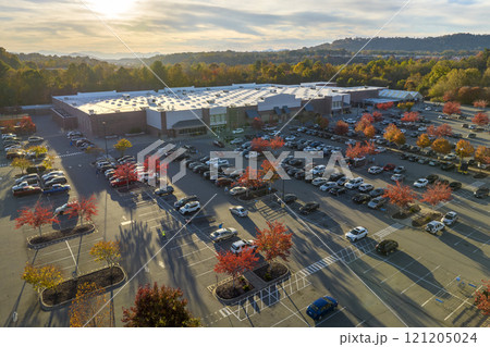 View from above of american grocery store with many parked cars on parking lot with lines and markings for parking places and directions. Place for vehicles in front of a strip mall center 121205024