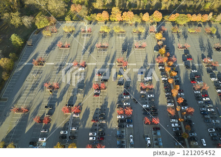 Top view of many cars parked on a parking lot in front of a strip mall plaza. Concept of consumerism and market economy 121205452