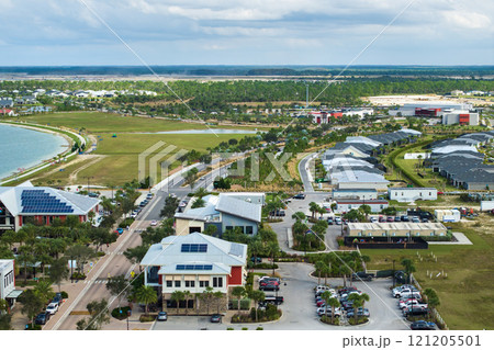 Solar rooftops in commercial center in Florida sustainable town. Photovoltaic panels for producing of clean ecological electrical energy in city area. Concept of autonomous building Solar rooftops in commercial center in Florida sustainable town. Photovoltaic panels for producing of clean ecological electrical energy in city area. Concept of autonomous building 121205501
