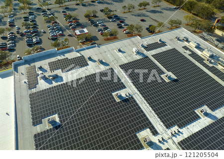Solar power plant with blue photovoltaic panels mounted on commercial shopping store building roof for producing green ecological electricity. Production of sustainable energy concept Solar power plant with blue photovoltaic panels mounted on commercial shopping store building roof for producing green ecological electricity. Production of sustainable energy concept 121205504
