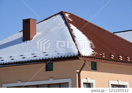 Snow guard for safety in winter on house roof top covered with steel shingles. Tiled covering of building Snow guard for safety in winter on house roof top covered with steel shingles. Tiled covering of building 121205512
