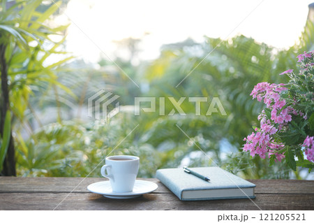 A White tea cup with Verbena flower and notebook, outdoor working 121205521
